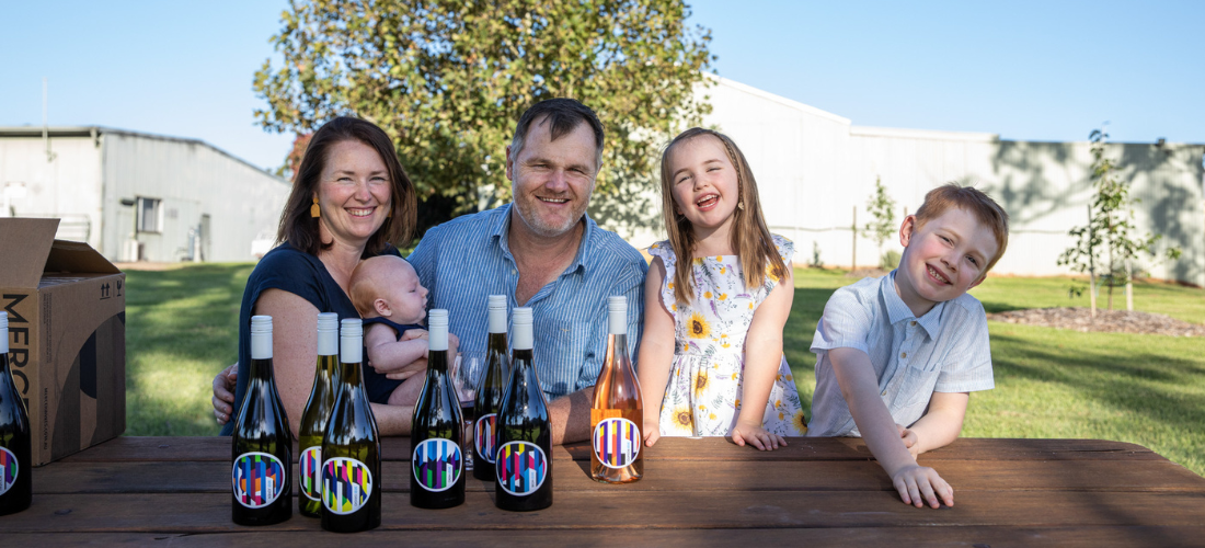 A family seated at a picnic table with bottles of Mercer Wines 